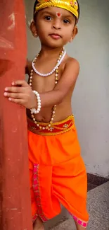 Child dressed as Krishna in vibrant attire.