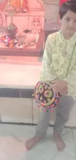 Child in traditional attire at a vibrant temple setting.