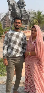 Couple in traditional attire by monument.