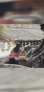 Woman admiring traditional architectural scenery on a mobile wallpaper.