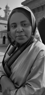 Black and white portrait of a woman in traditional attire with architectural background.