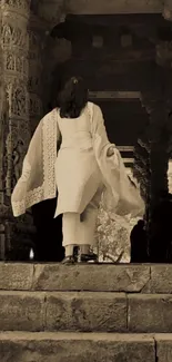 Woman in traditional dress walks through ancient stone archway.