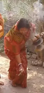 Woman in vibrant saree performing a traditional ritual outdoors.