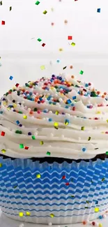 Cupcake with blue wrapper and sprinkles on white background.