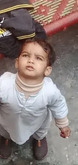 Child looking up in an urban courtyard setting.