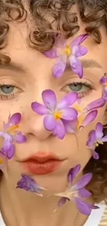 Face with curly hair adorned with purple flowers.