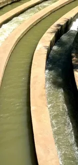 Curved concrete aqueduct with flowing water.