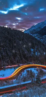 Curved road with light trails in snow-covered mountains at night.