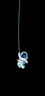 Cute astronaut dangling on a string against a black background in a mobile design.