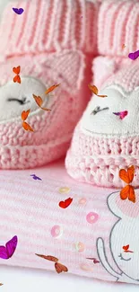 Pink baby booties on a pastel stack with cute design.