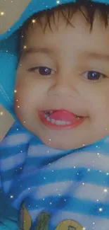 Adorable baby in blue hoodie with stars and a cute smile.