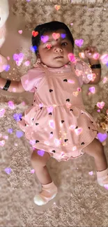 Cute baby in pink dress with heart effects and teddy bear around.