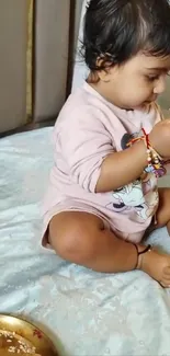 Adorable baby enjoying playtime on a bed.