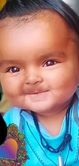 Cute baby smiling with a heart decoration.