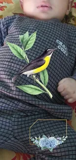 Cute baby with bird and floral embroidery on outfit.