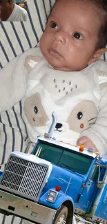 Adorable baby and blue truck on fabric.