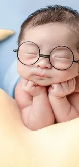 Adorable baby with glasses resting on a soft beige pillow.