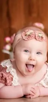 Cute baby girl in pink with floral headband smiling.