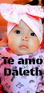 Baby with pink bow and 'Te amo Daleth' text.