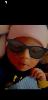 Cute baby wearing sunglasses and a pink hat.