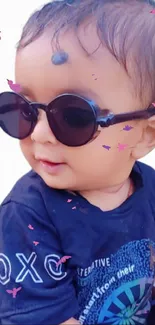 Cute baby wearing sunglasses with playful butterflies.