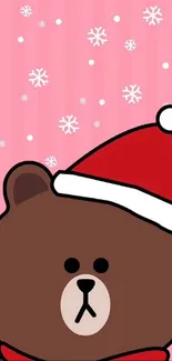 Cute brown bear with Santa hat on pink background.