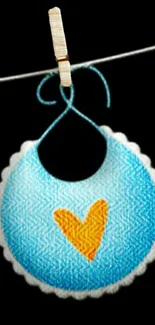 Cute blue bib with yellow heart on black background.