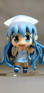 Anime figurine with blue hair and dress, standing cheerfully.