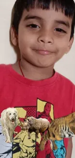 Smiling boy in a red superhero shirt with illustrated animals.