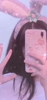 Girl with bunny ears taking a selfie with a pastel-colored phone.