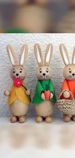 Three adorable wooden bunny figurines dressed in colorful attire.