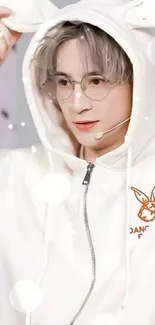 Person in a white bunny-eared hoodie and glasses.