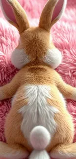 Cute bunny lying on a pink fluffy blanket.