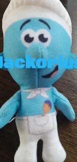 Plush cartoon toy with blue color on wooden surface.