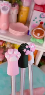 Cute mobile wallpaper with cat paw pens in pastel colors.