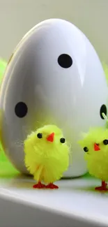 Adorable yellow chicks with a dotted egg on mobile wallpaper.