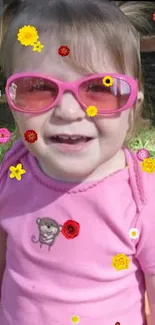 Smiling child with pink sunglasses and floral accents.