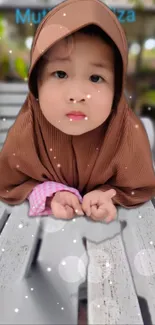 Cute child in a brown hoodie with bokeh background.