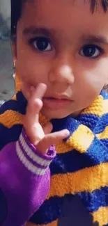 Cute child with a purple and yellow striped sweater.