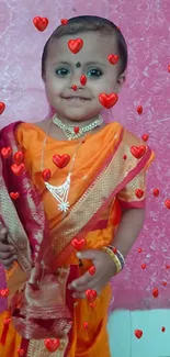 Adorable child in orange saree with hearts effect.