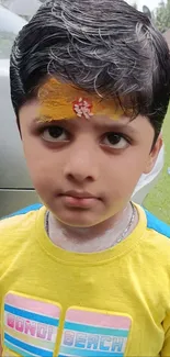 Cute young boy in a bright yellow shirt.