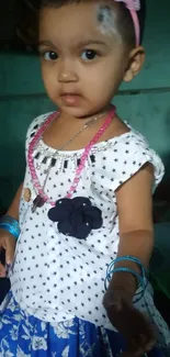 Cute toddler with starry outfit and pink headband.