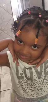 Cute child smiling with colorful beads in hair indoors.