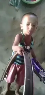 Child holding a toy bus in a playful setting.