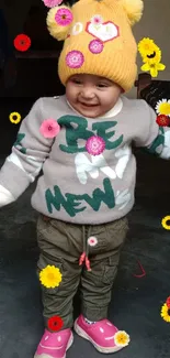 Smiling baby in winter clothing with a yellow beanie.