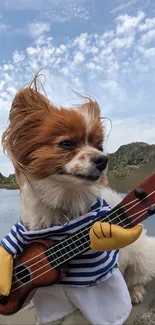 Adorable dog wearing striped shirt and holding guitar by a lake.