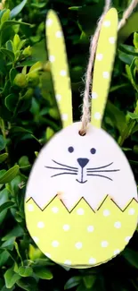 Cute Easter bunny egg with yellow polka dots in green foliage.