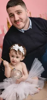 Father and daughter playful moment with balloons and pink theme.