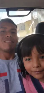 Father and daughter taking a car selfie.