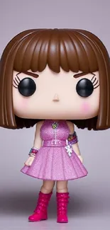 Cute figurine in pink dress with brown hair against a neutral background.